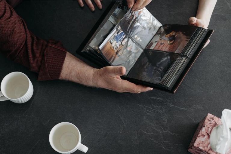 Hands holding an open wedding album on a table