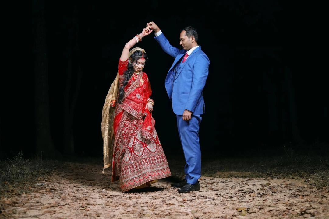 Couple twirling on a dark lawn at night
