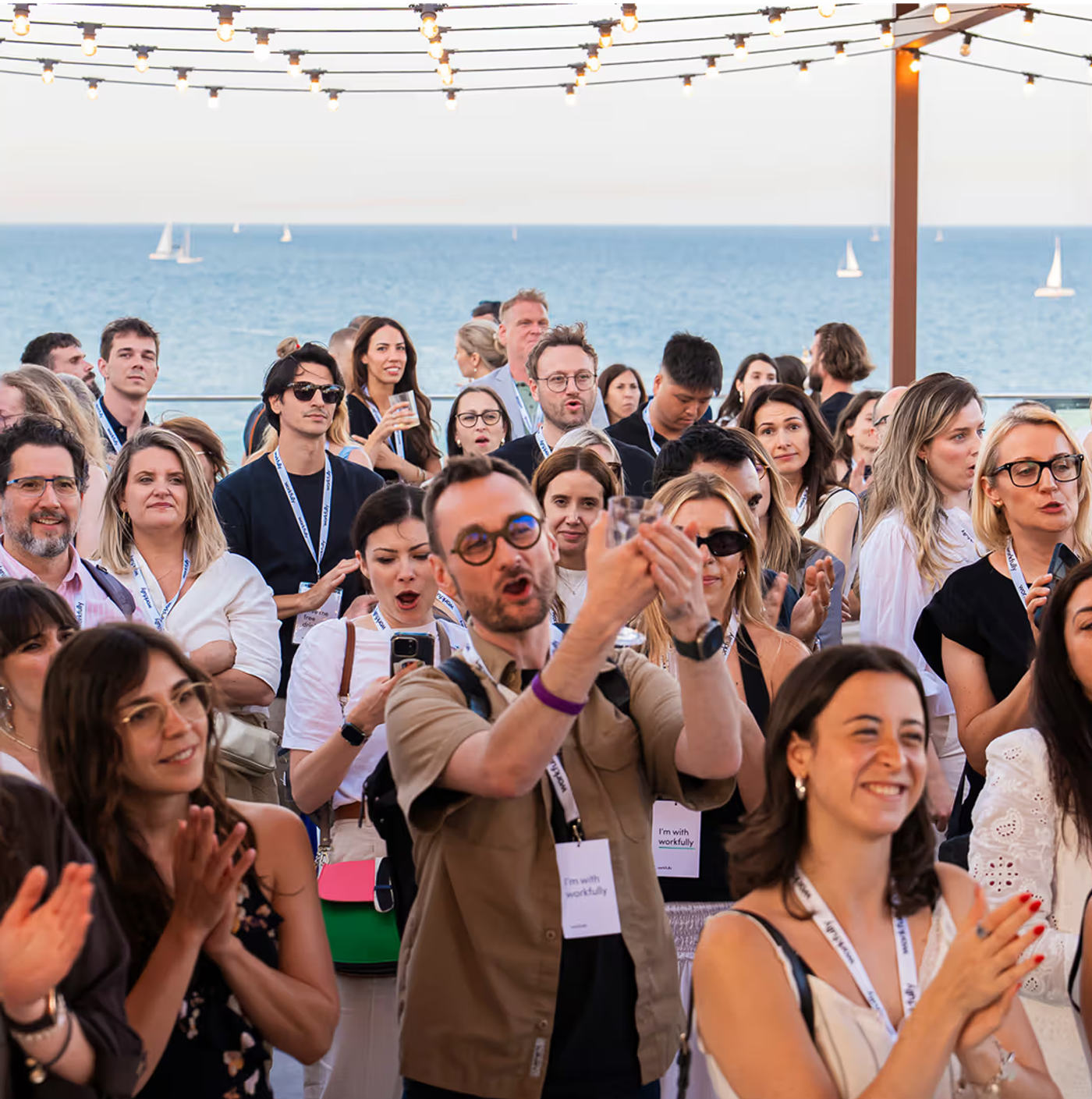 Guests celebrating at an outdoor Workfully event overlooking the sea