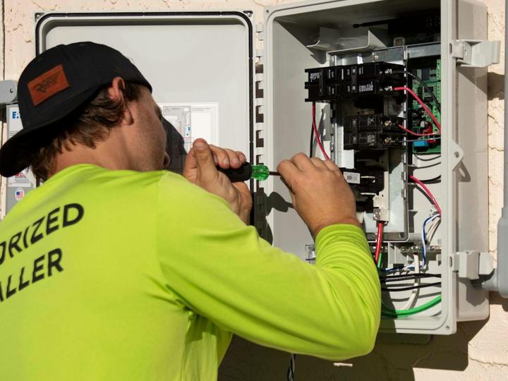 Tecnico al lavoro su un quadro elettrico aperto