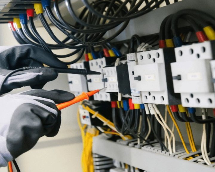 Elettricista che verifica un quadro elettrico con il tester