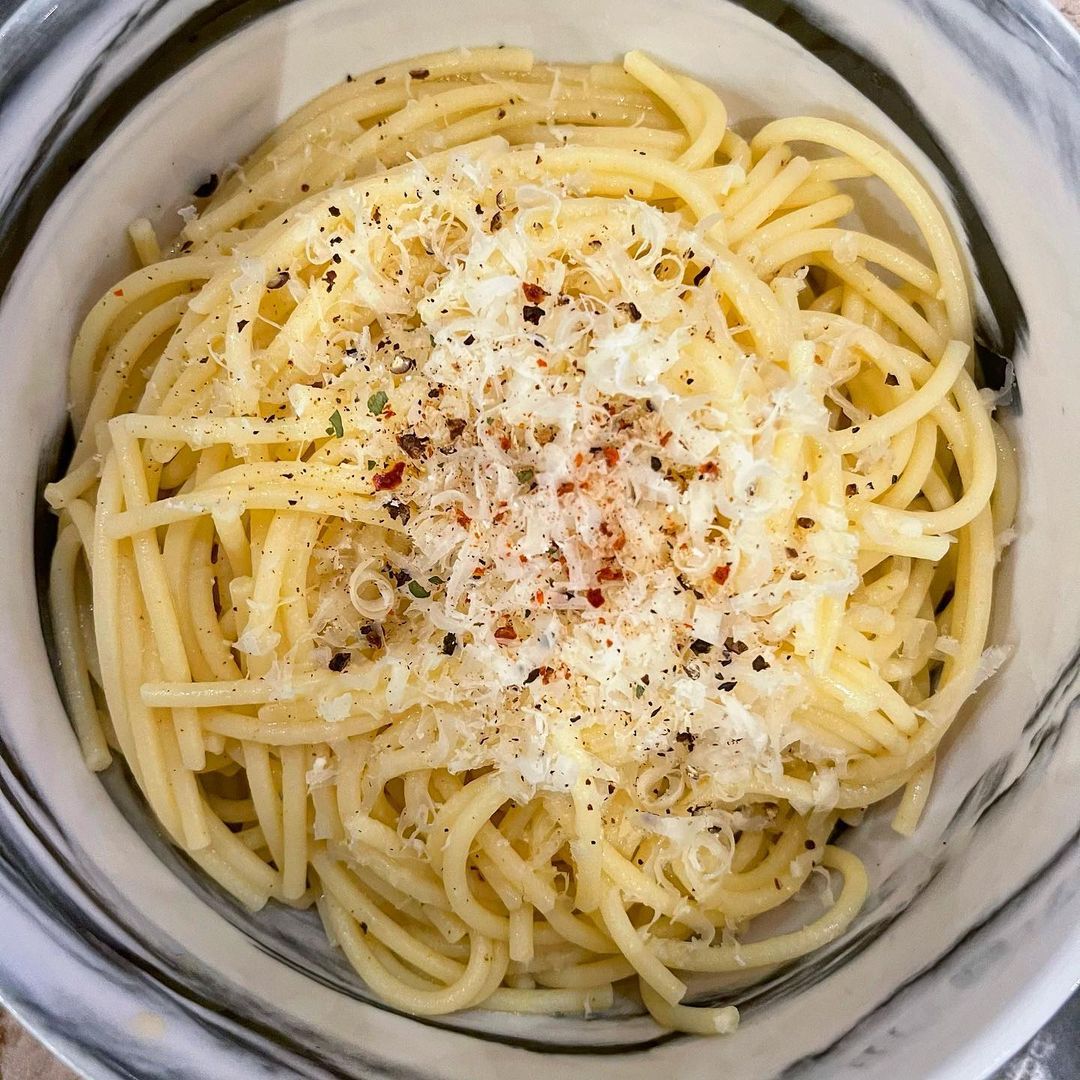 Bowl of spaghetti with parmesan and herbs on top