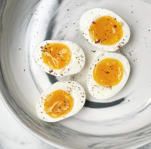 Two jammy eggs cut in half topped with fresh cracked black pepper. 