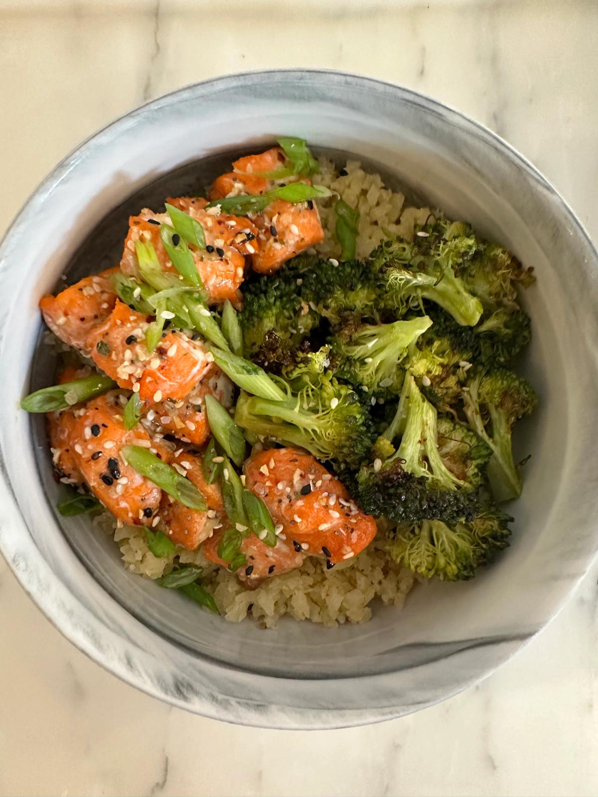 Bowl with rice, greens, and salmon topped with JF salt
