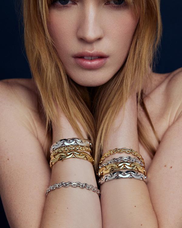 woman wearing multiple coloured stacked chain bracelets 
