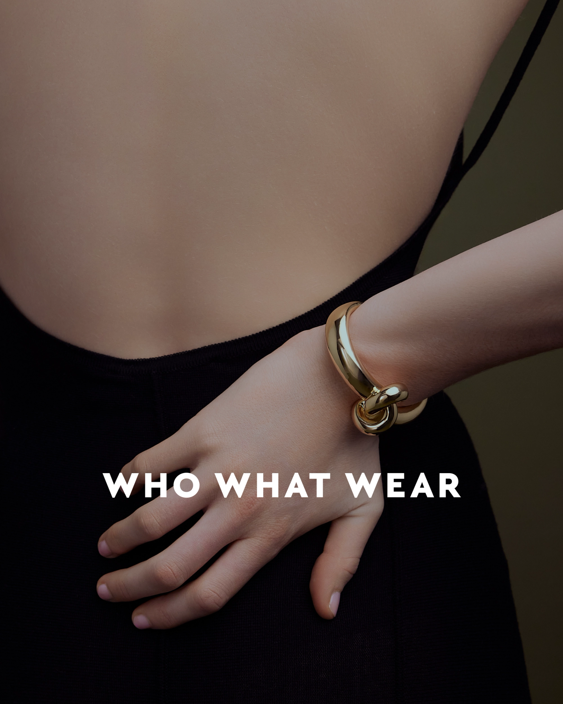 model with her hand on her back with a gold cuff on