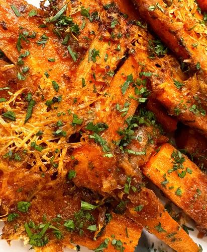 Roasted carrots covered in melted vegan parmesan cheese