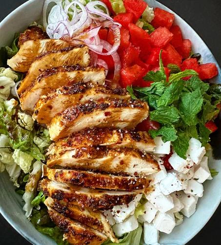 Salad topped with watermelon, feta and chicken 