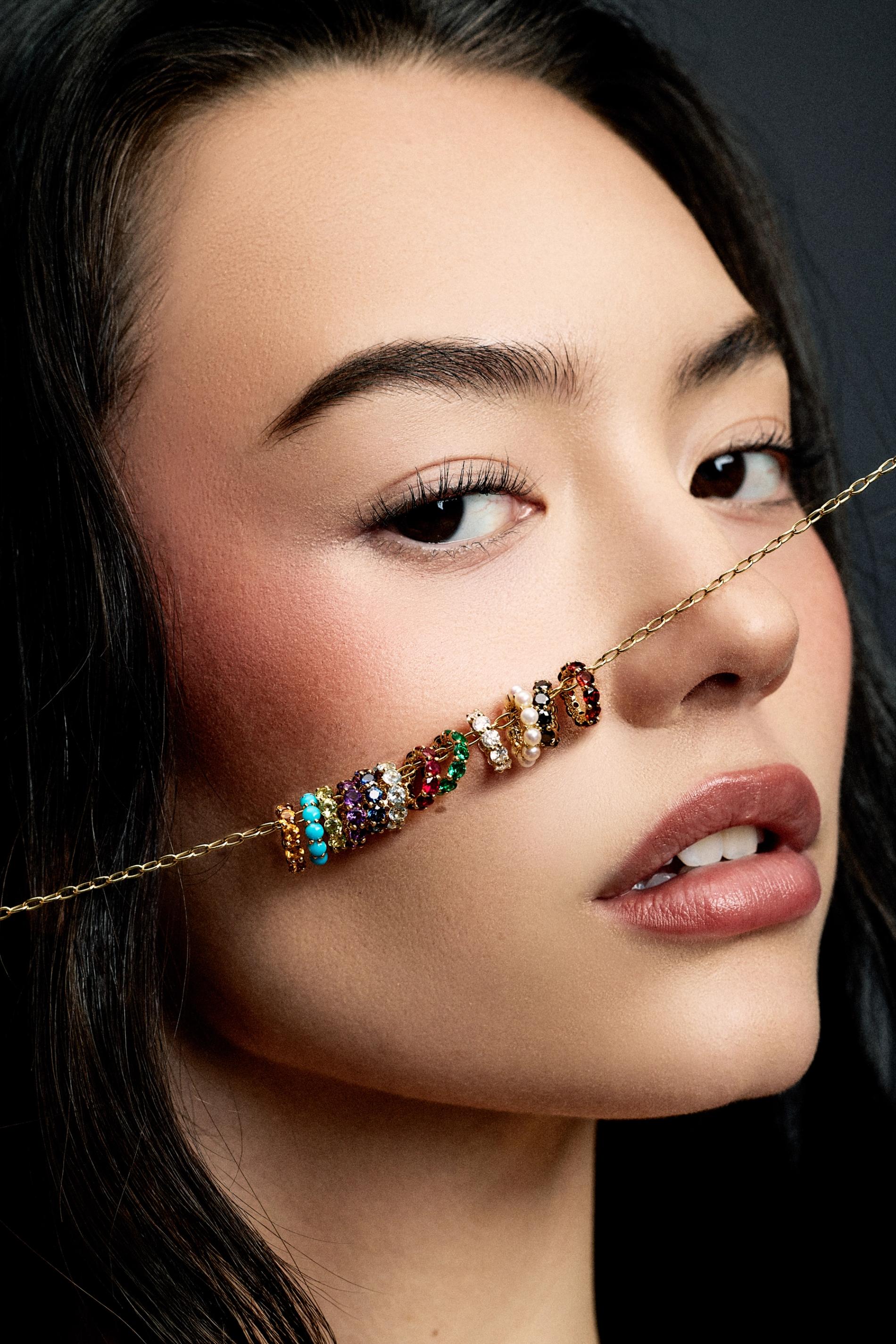 Model with charm necklace on her hand spelling out mom