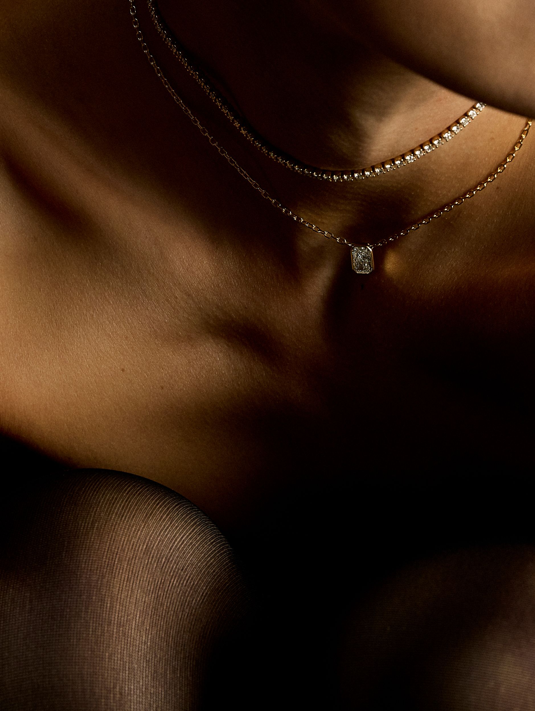 Model in tights and a lab necklace and a lab diamond pendant