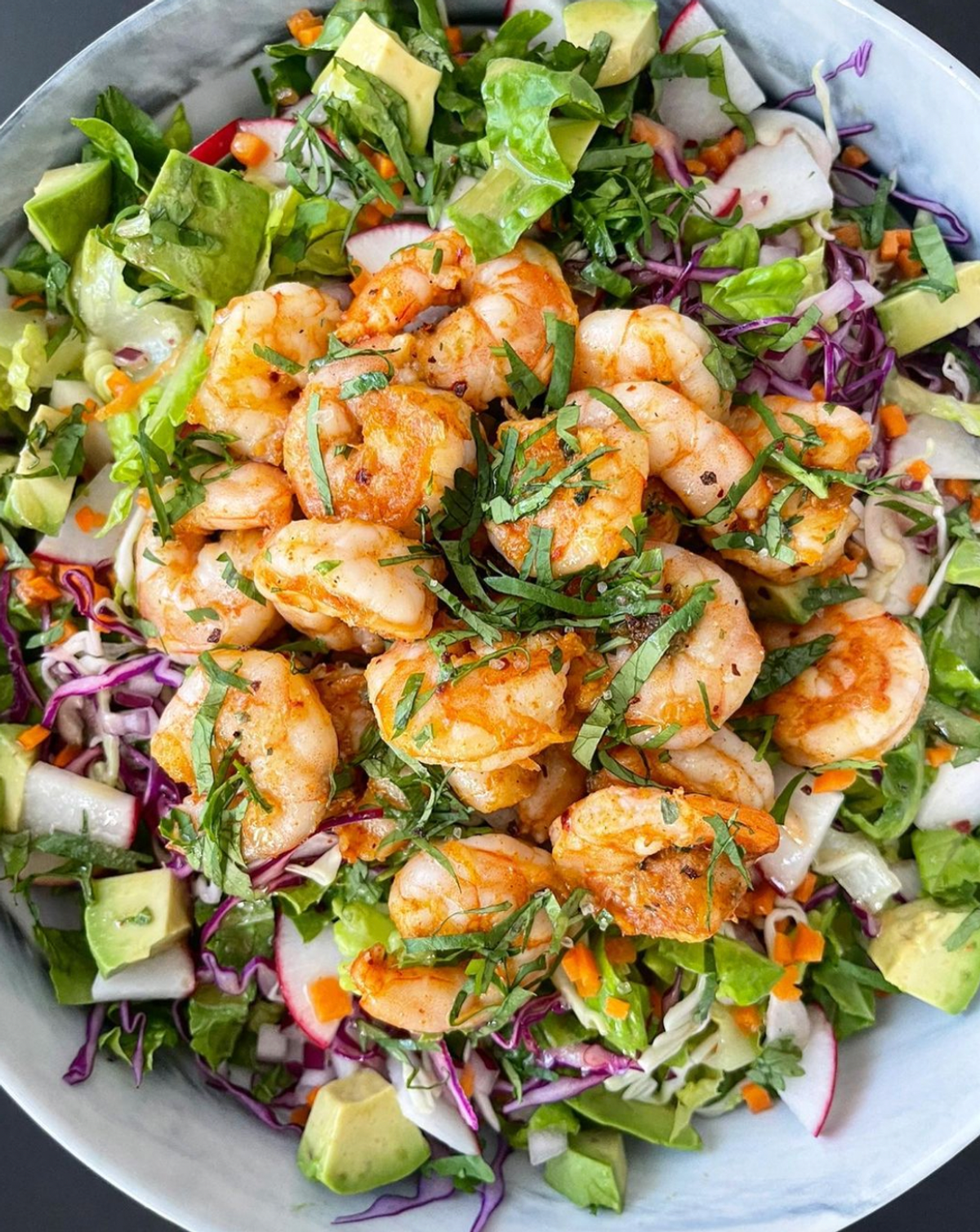 Picture of shrimp mixed in a salad in a bowl