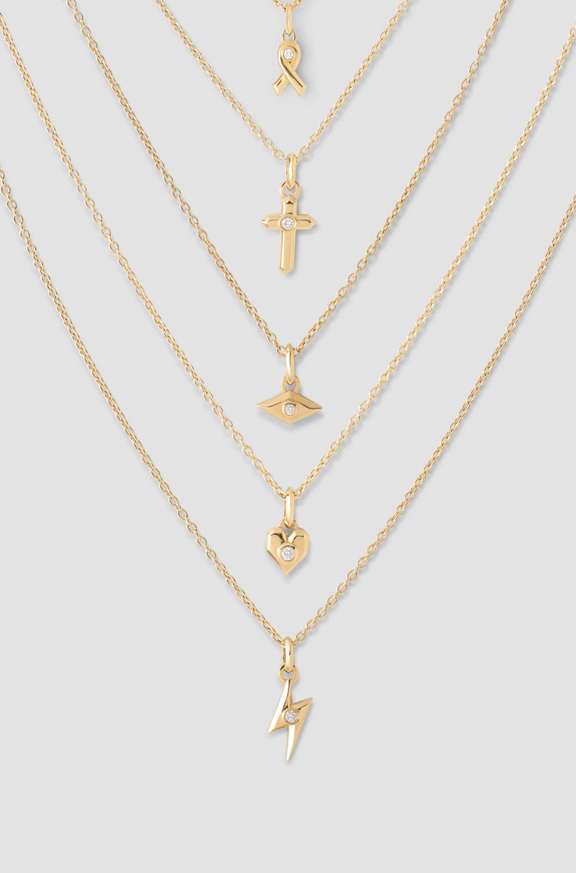 Gold chains and charms on a grey background