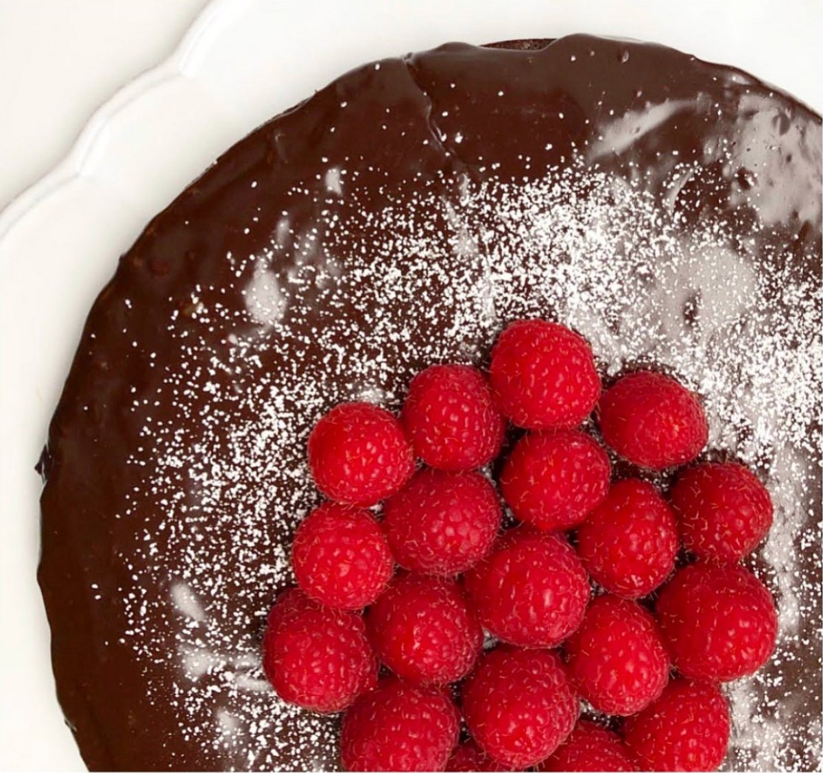 Flourless chocolate cake with powdered sugar and raspberries