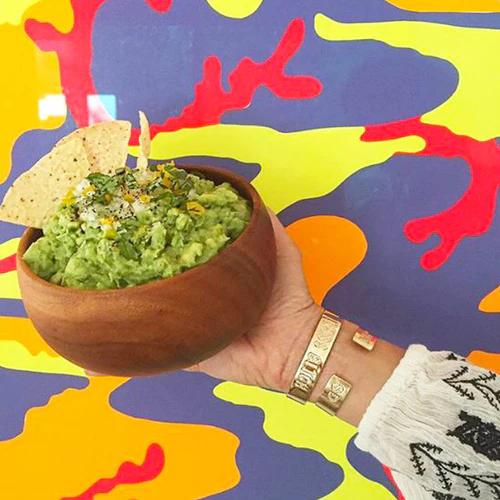 Bowl packed with fresh California Style Guacamole. Garnished with 3 tortilla chips on top.