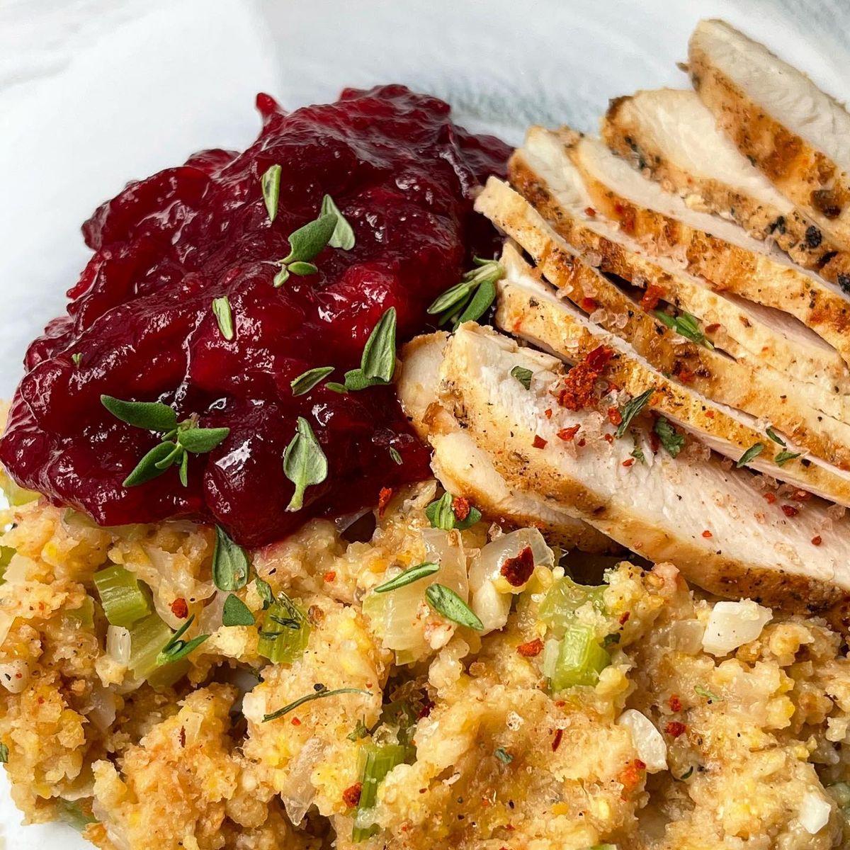 Picture of Cranberry sauce next to rice and chicken on a plate
