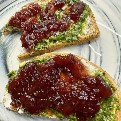 Two slices of grain free bread smothered with vegan feta, vegan pesto and jam. 