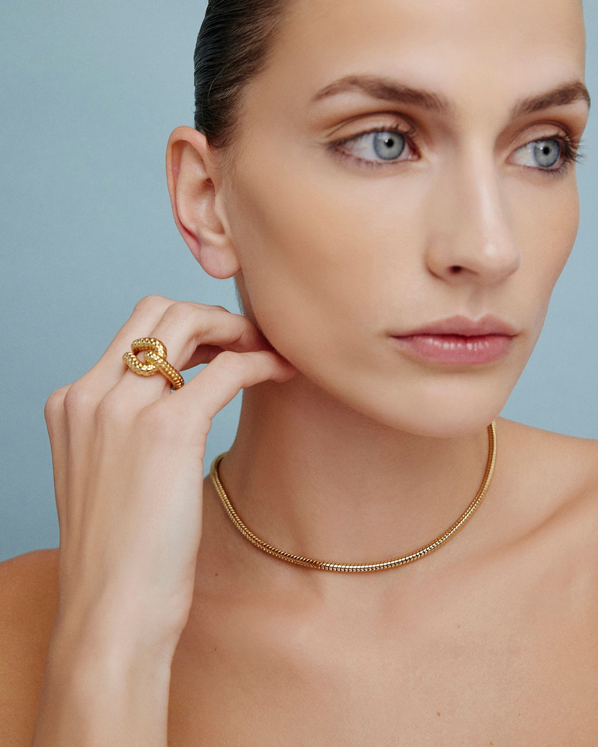 Model in lightweight gold star earrings on a blue background