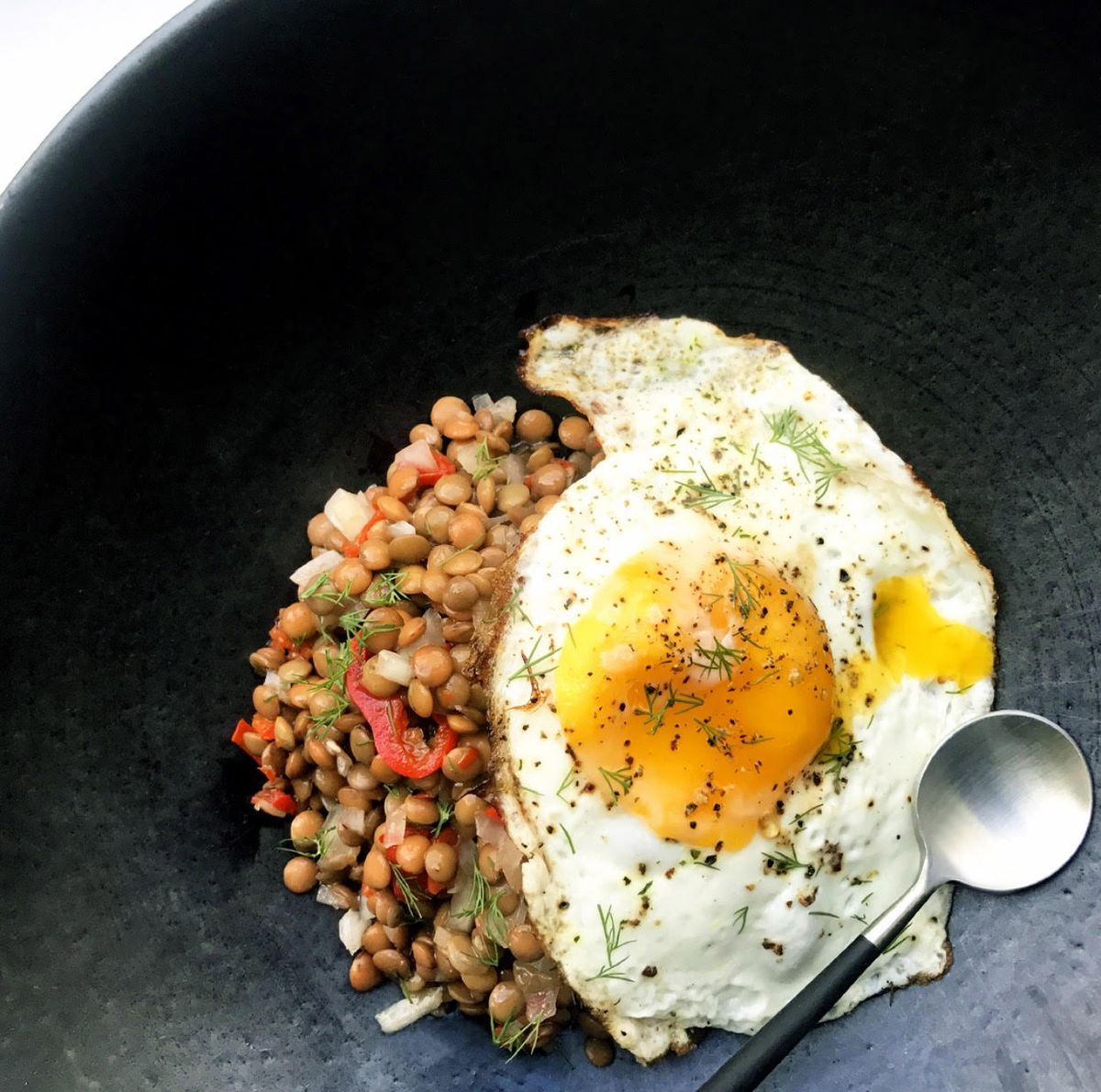 Egg over a lentil salad in a bowl