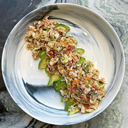 Flaked tuna packed with diced carrot, celery, banana pepper, red onion, purple cabbage and torn dill plated with avocado and a sprinkle of JF Spicy Salt.