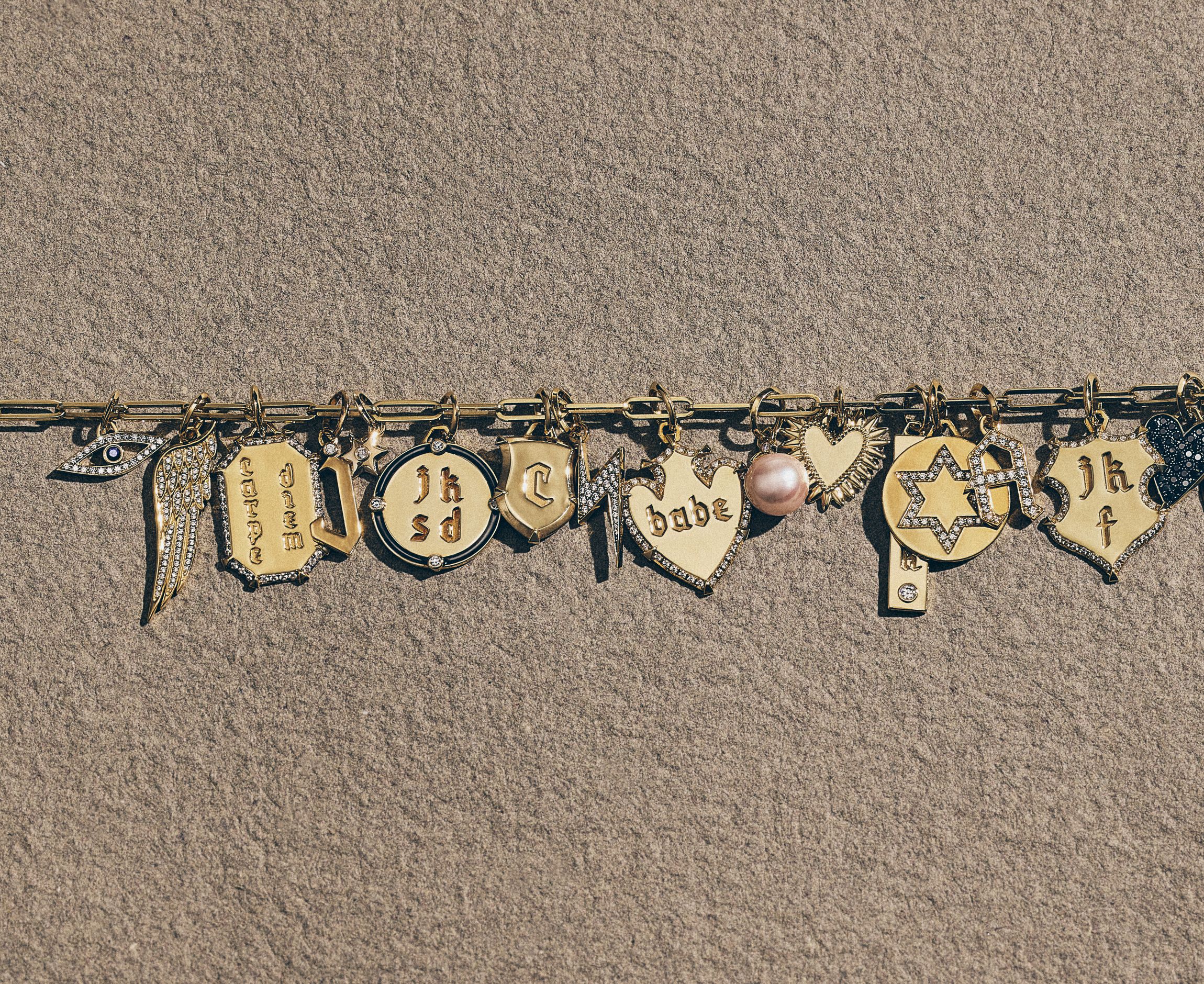 Model with charm necklace on her hand spelling out mom