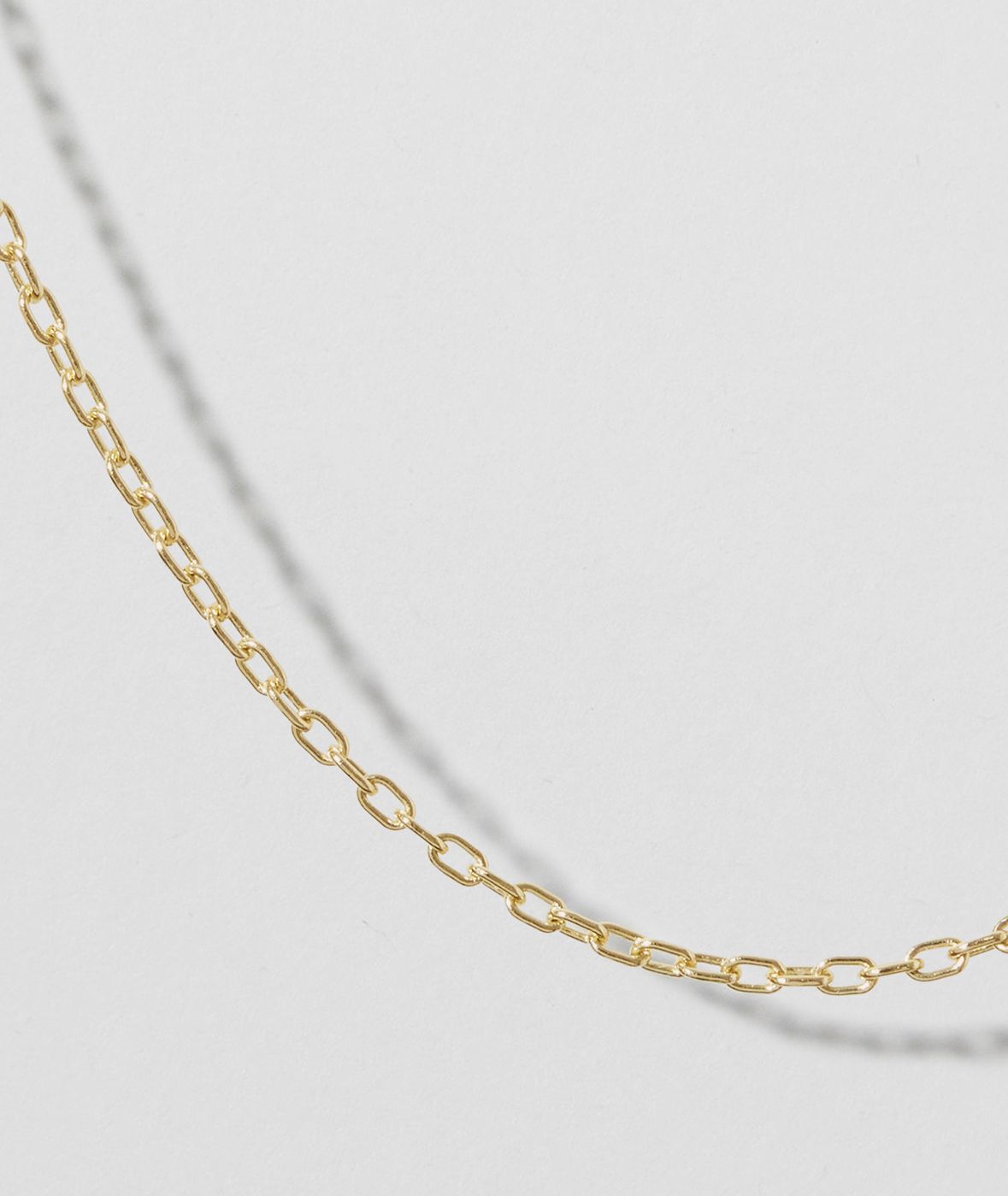 Yellow gold chain on a grey background
