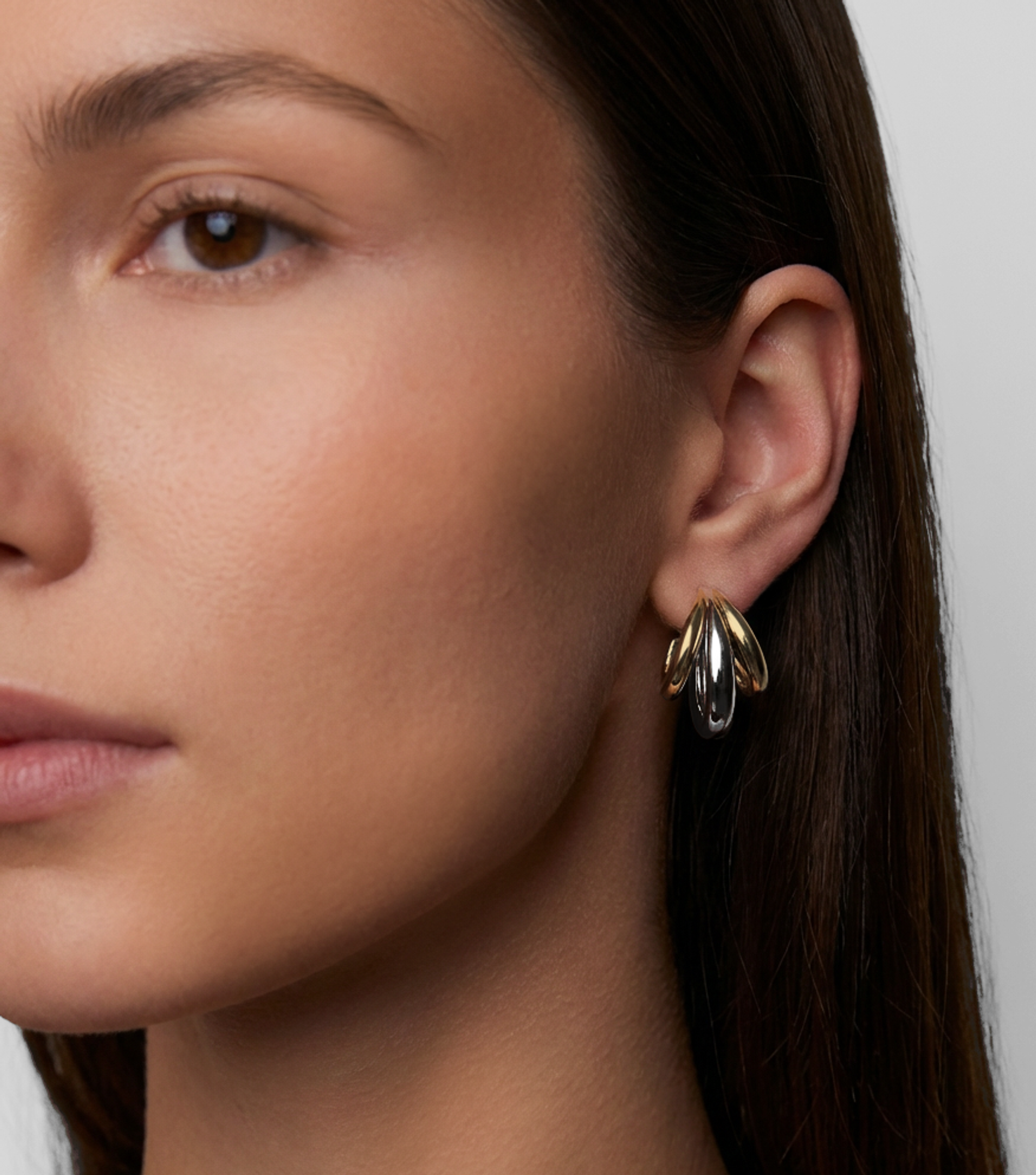 Model with two tone triple lilly hoops