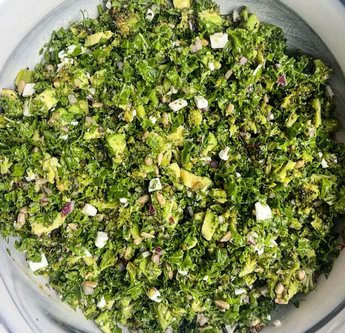 Image of kale salad with avocado, red onion, and feta