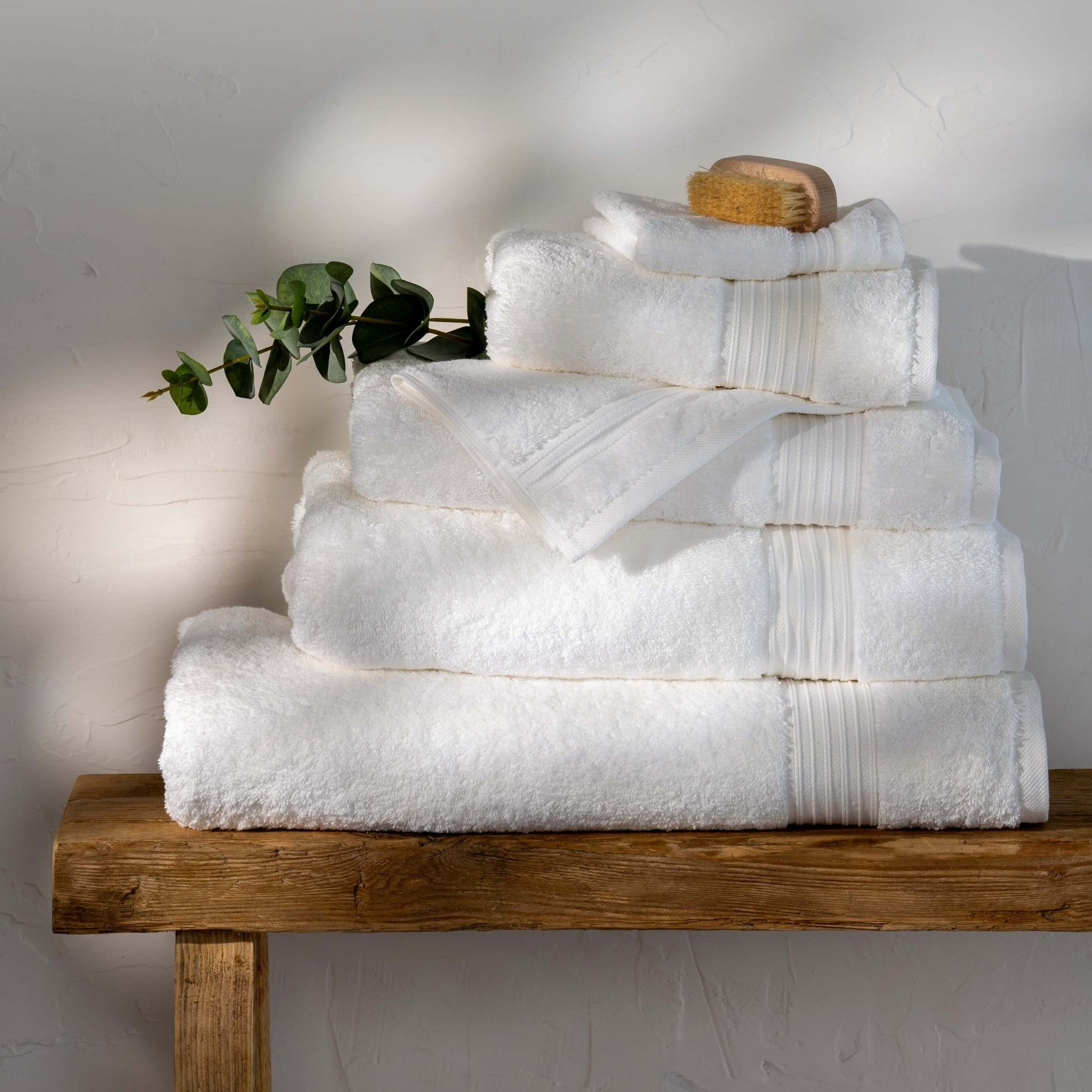 Stapel witte handdoeken op een houten bankje