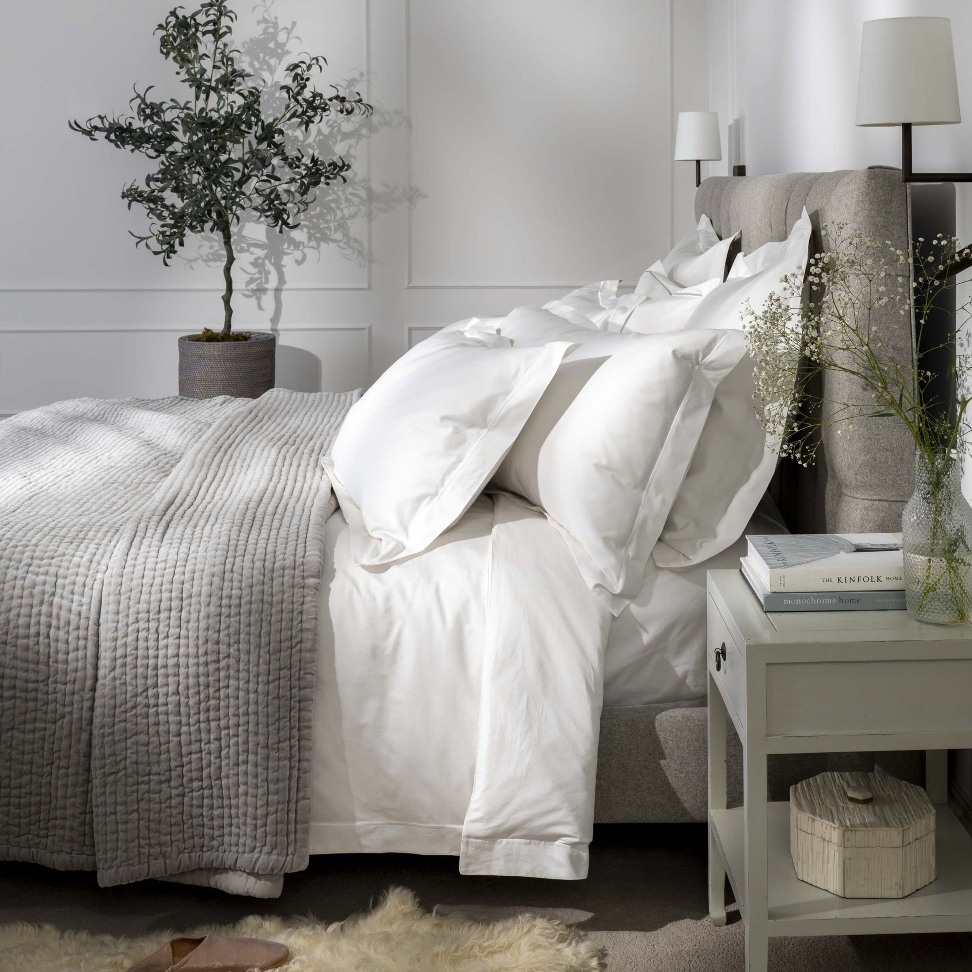 Bed opgemaakt met wit katoenen beddengoed