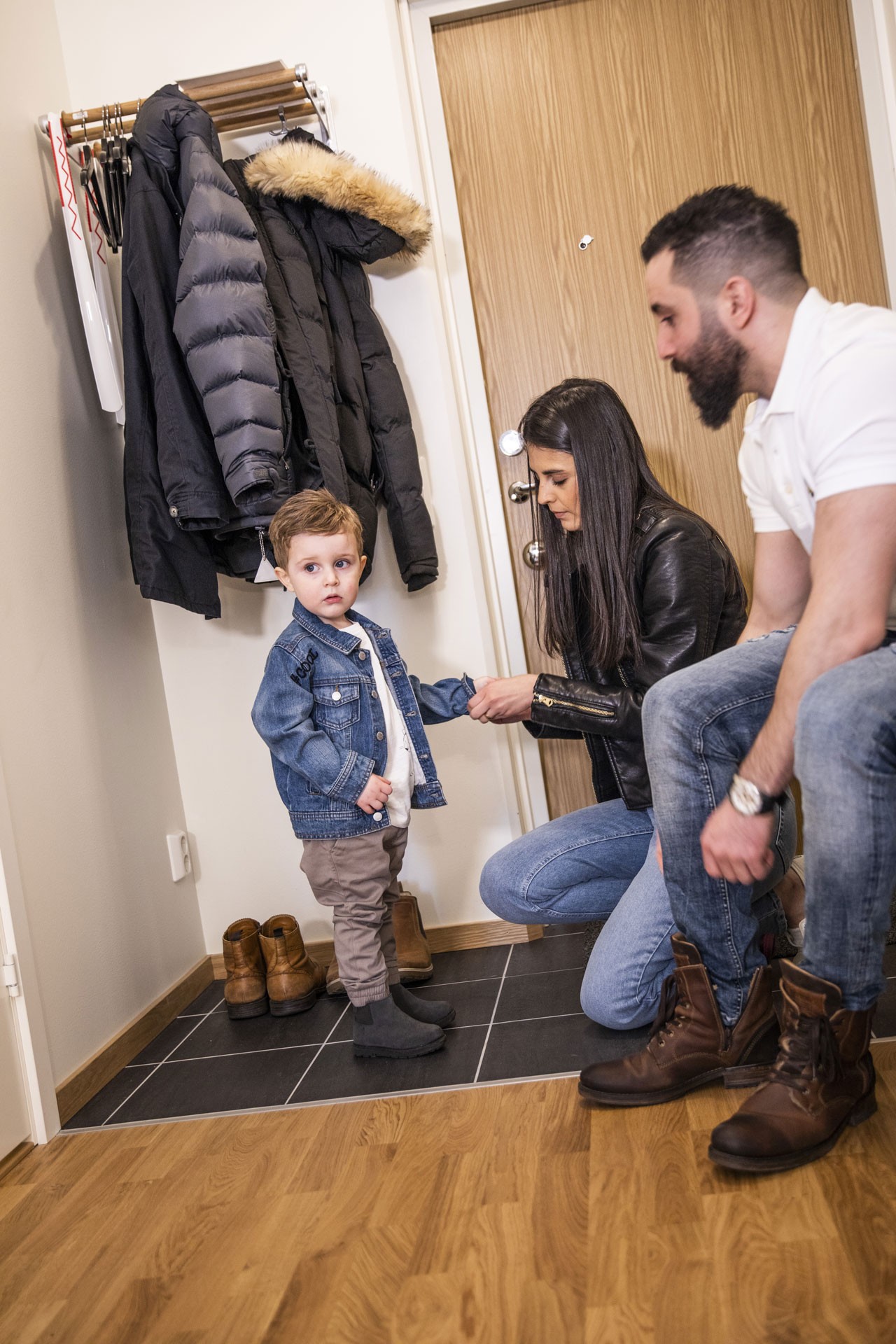 Familj som tar på sig kläder i en hall