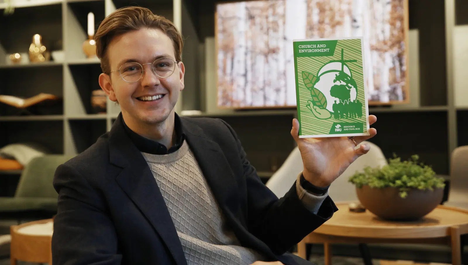 Bild på Johannes Widlund som håller i boken Church and Environment.