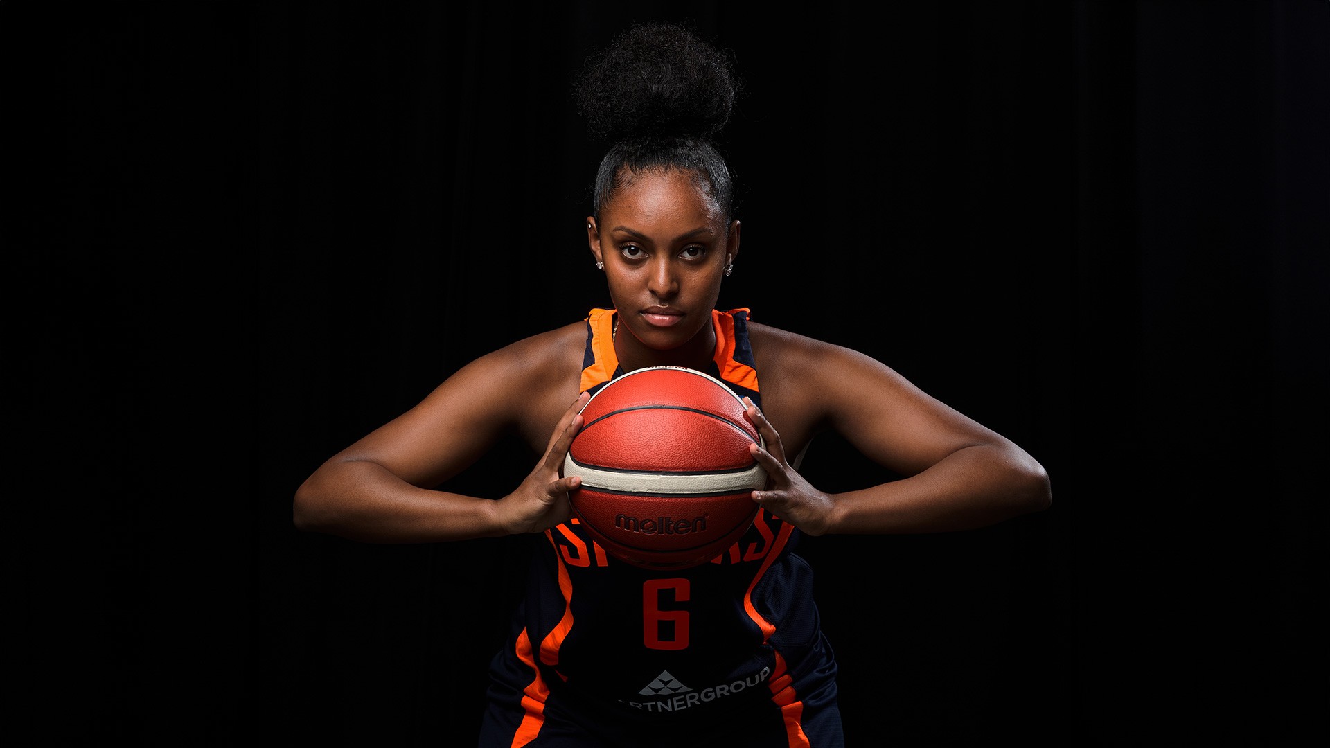 Närbild på kvinnlig basketspelare med basketboll i händerna.