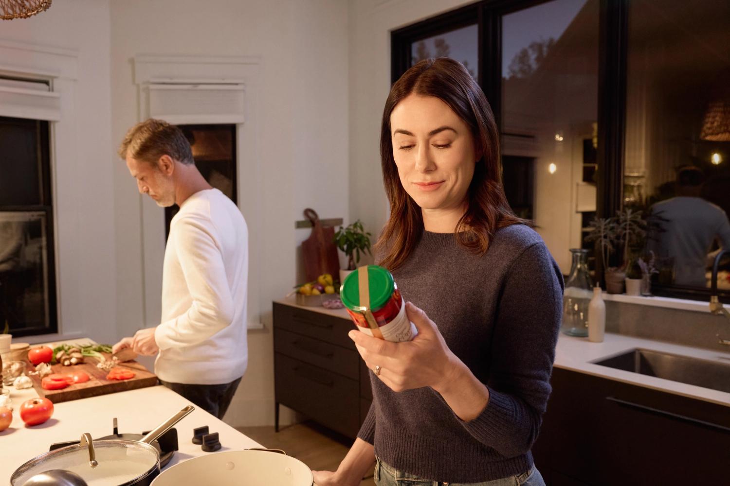 woman sees small print in kitchen after using VIZZ eye drops aceclidine ophthalmic solution 1.44%