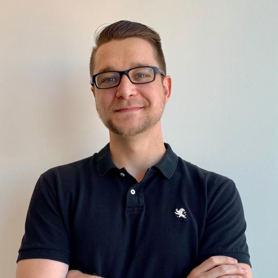 Professor Brandon Reagen posing in front of a white wall