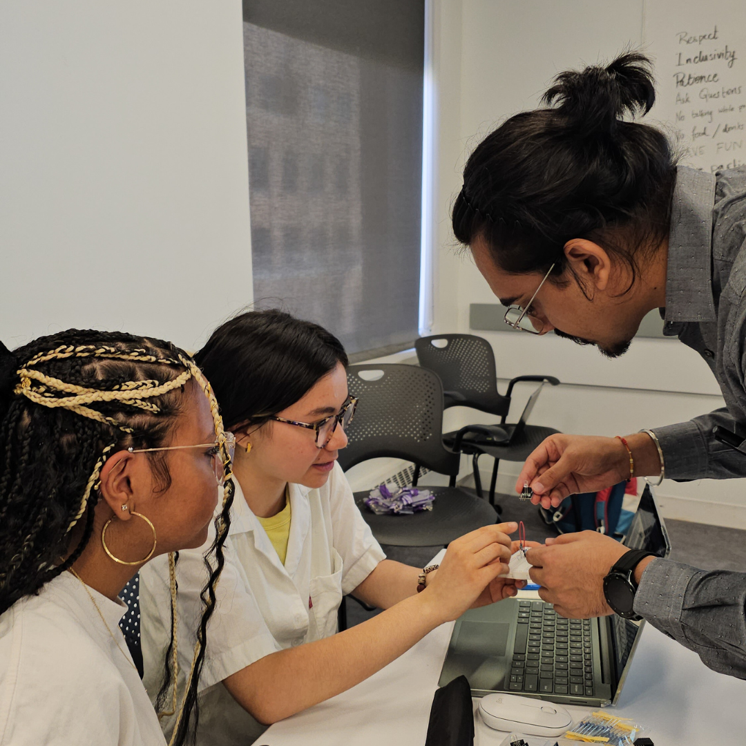 An instructor assisting two students with an electronics project at NYU Tandon’s K12 STEM Center