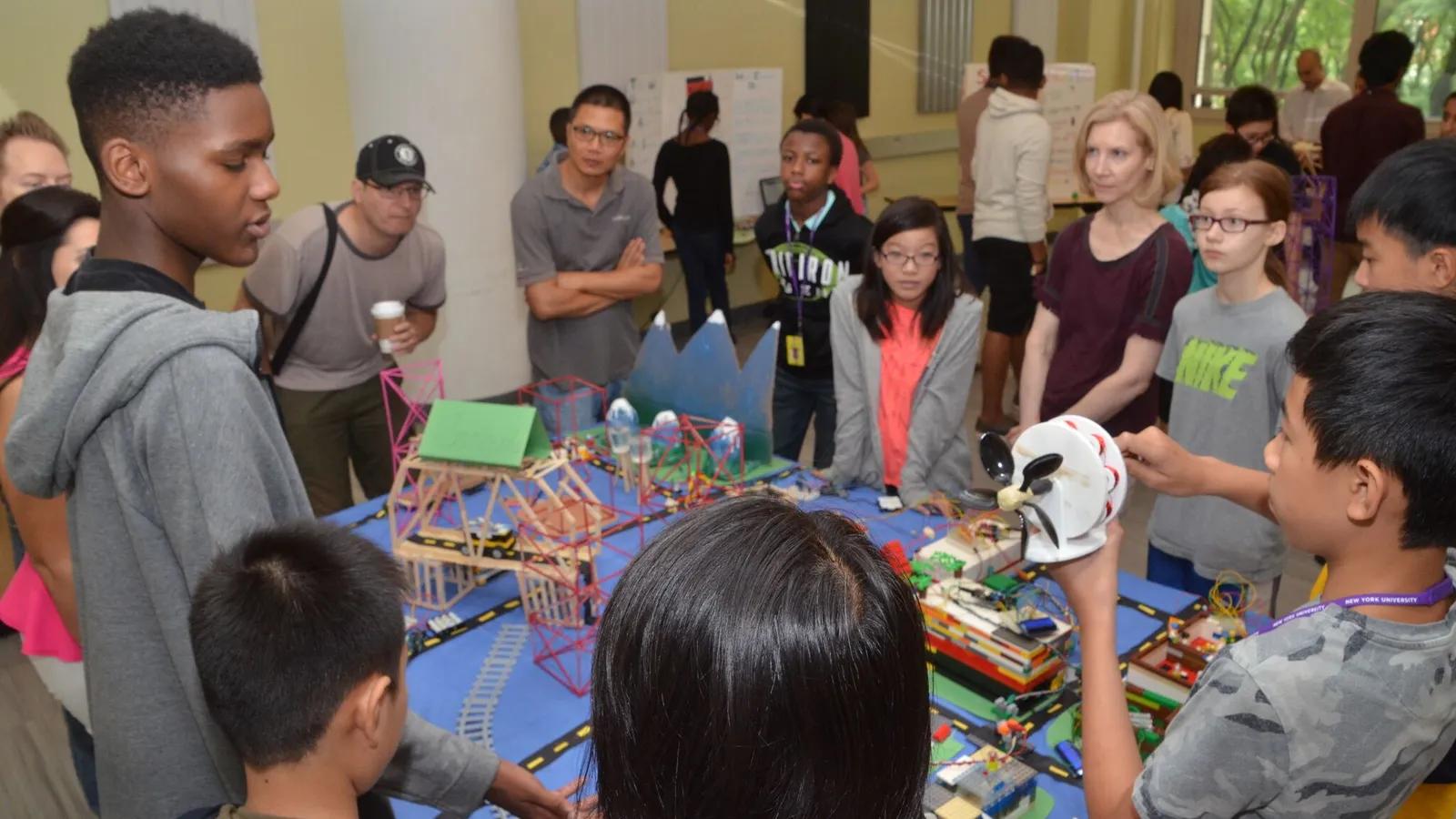 Group of SOSC students gathered around their final city project