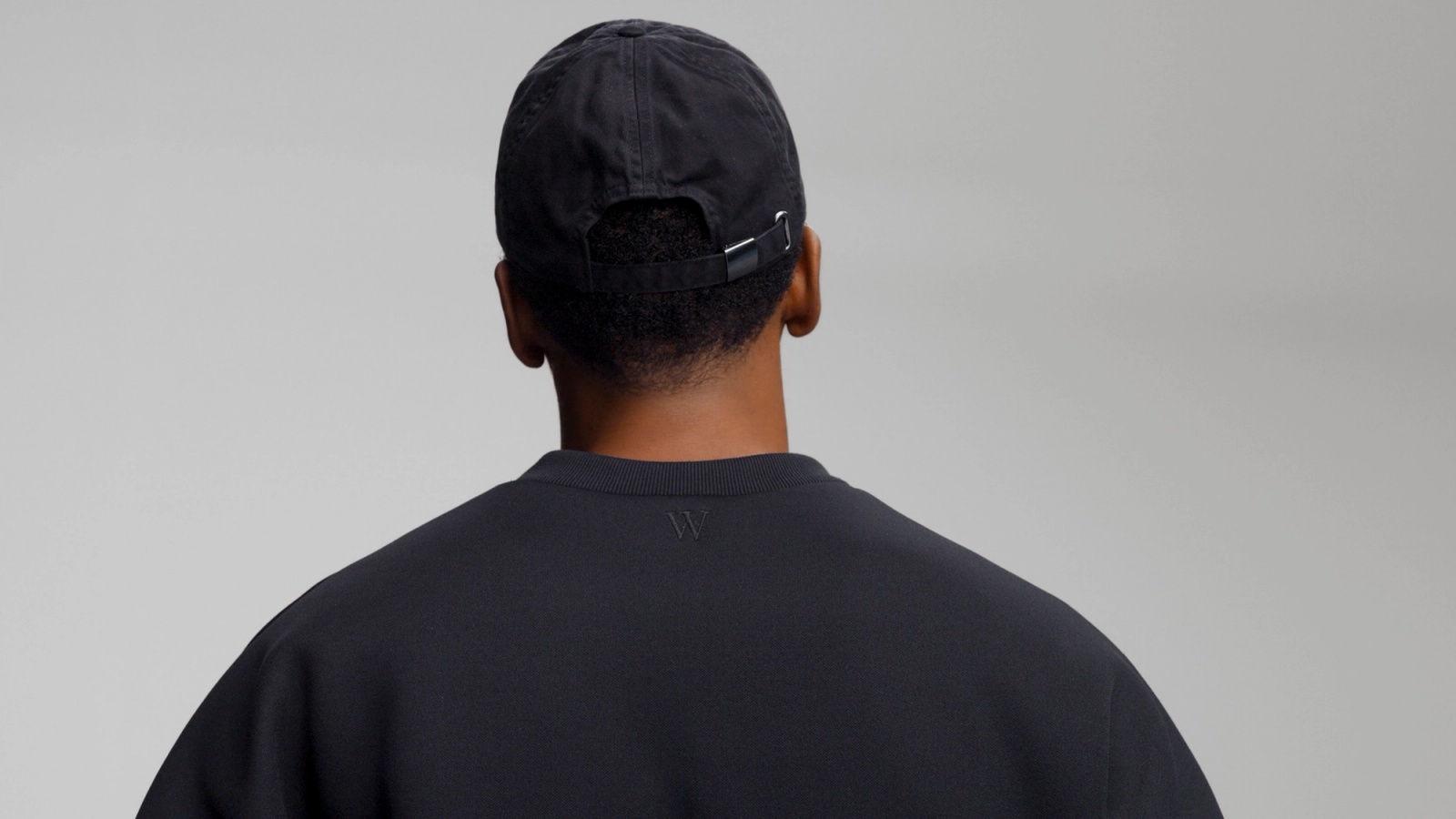 Close up of the embroidered logo on the back of Glenwood's Signature Crewneck in Black