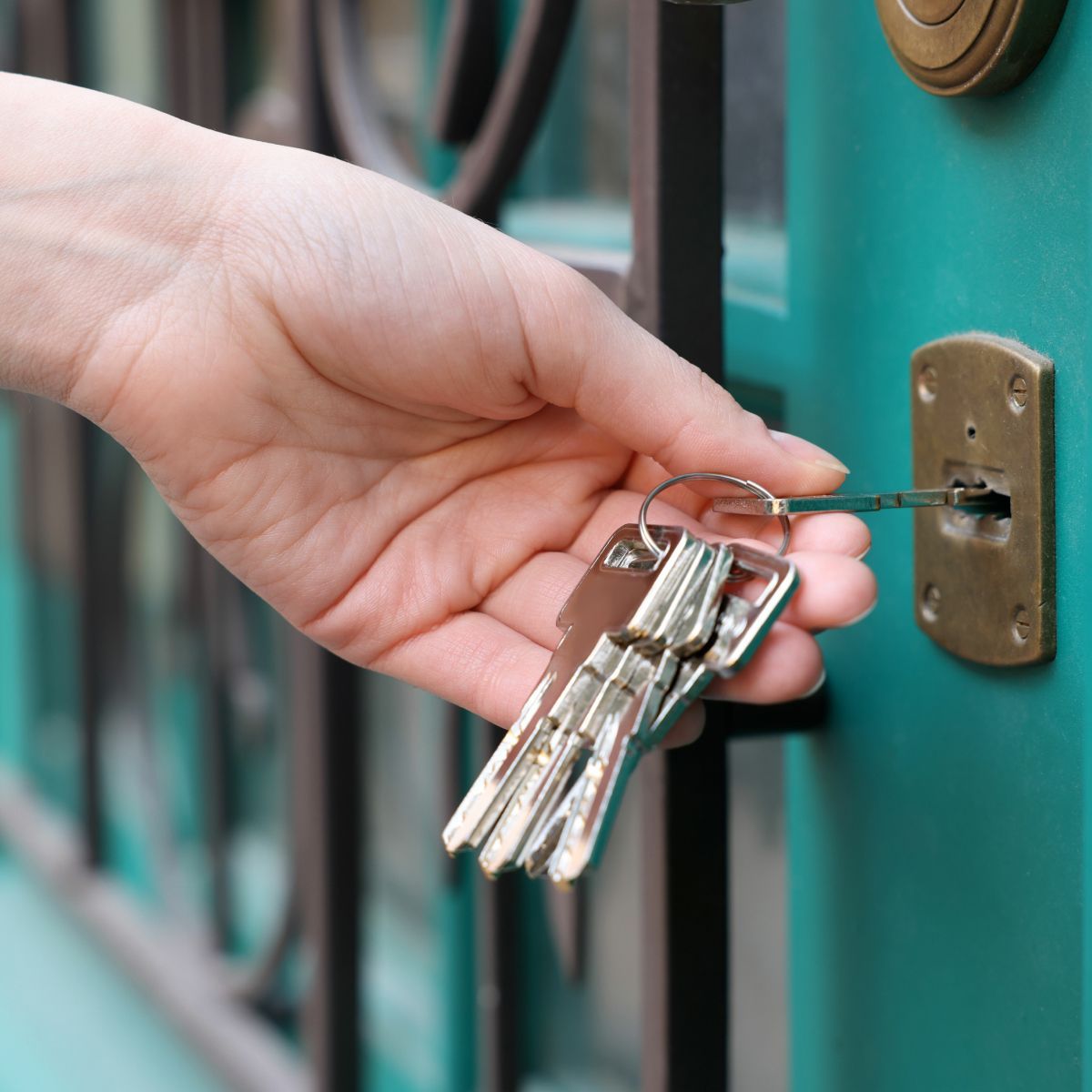 Hand holding keys and unlocking door
