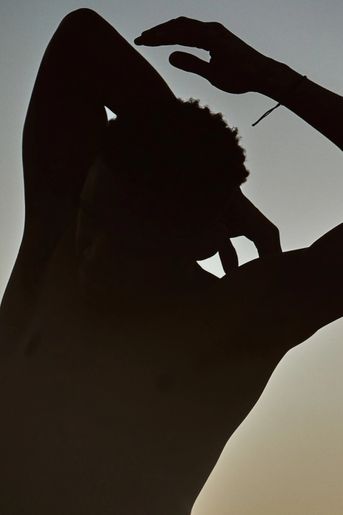 Man stretching against sunset