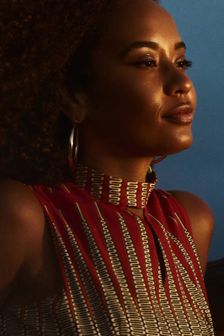 Young black woman stares calmly into ocean