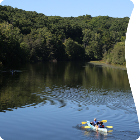 Scenic view of a lake with two people kayaking