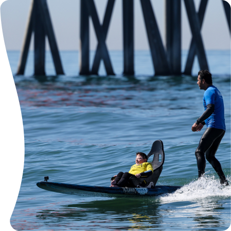 young boy taking surfing's class with an instructor