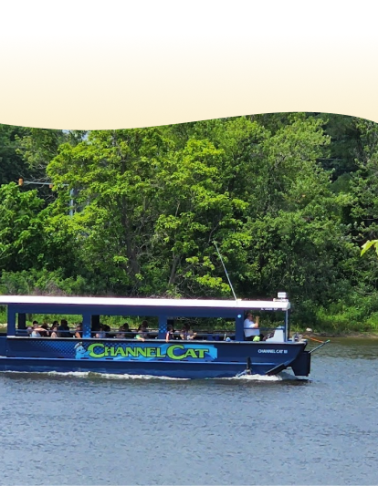 people ride along the Mississippi River in a Channel Cat Water Taxi