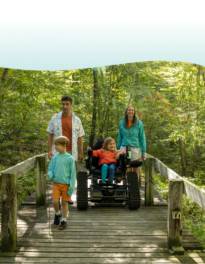 Girl in a wheelchair riding around a bridge with her family