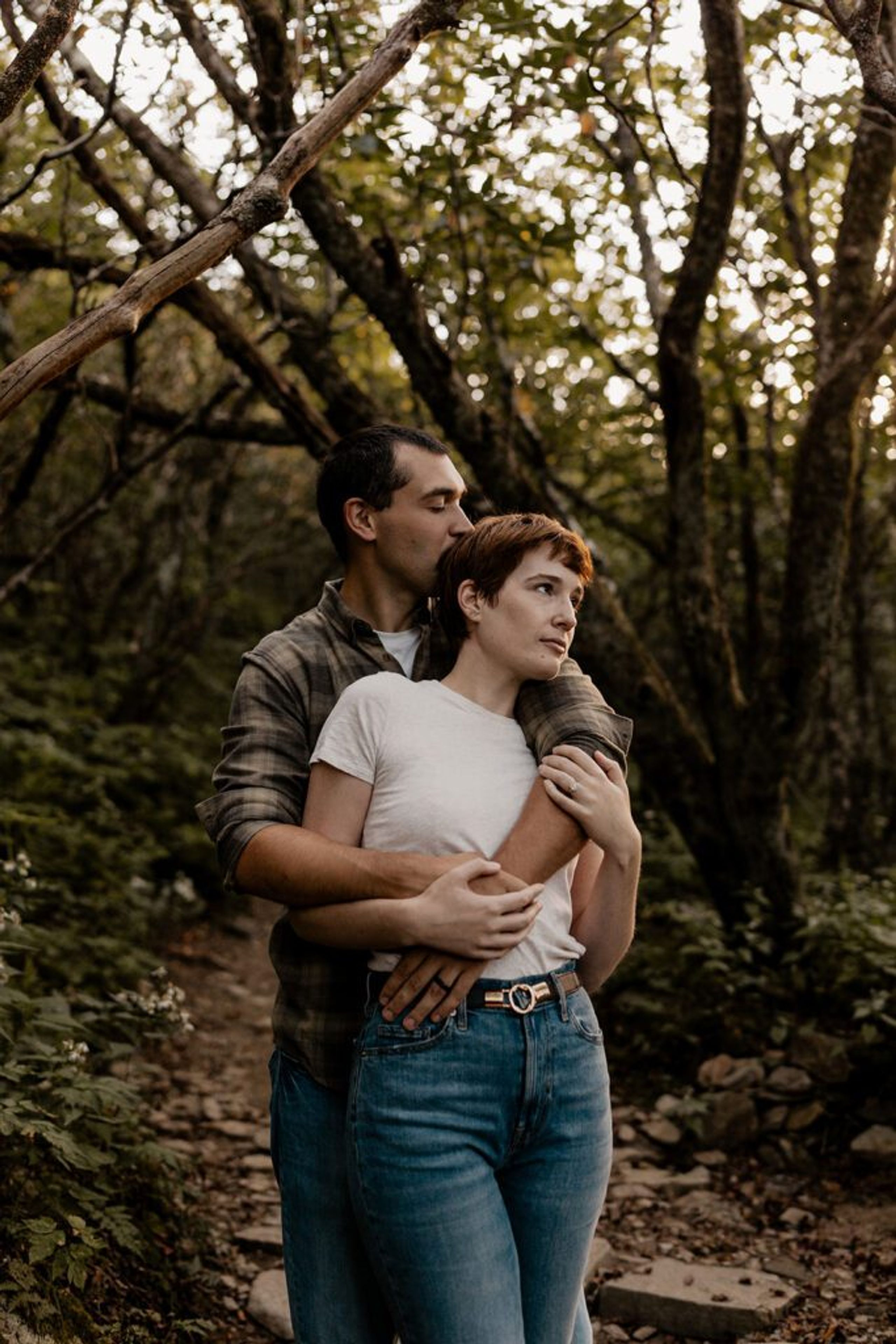 Couple embracing in the lush forest at Craggy Gardens during their engagement session.