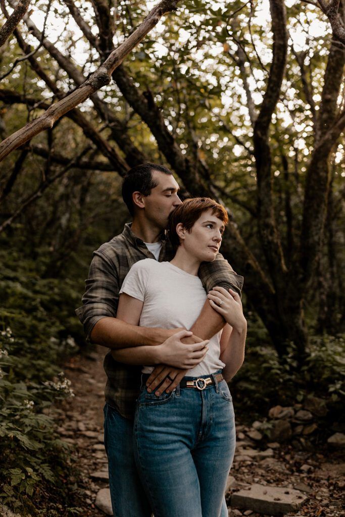 Couple embracing in the lush forest at Craggy Gardens during their engagement session.