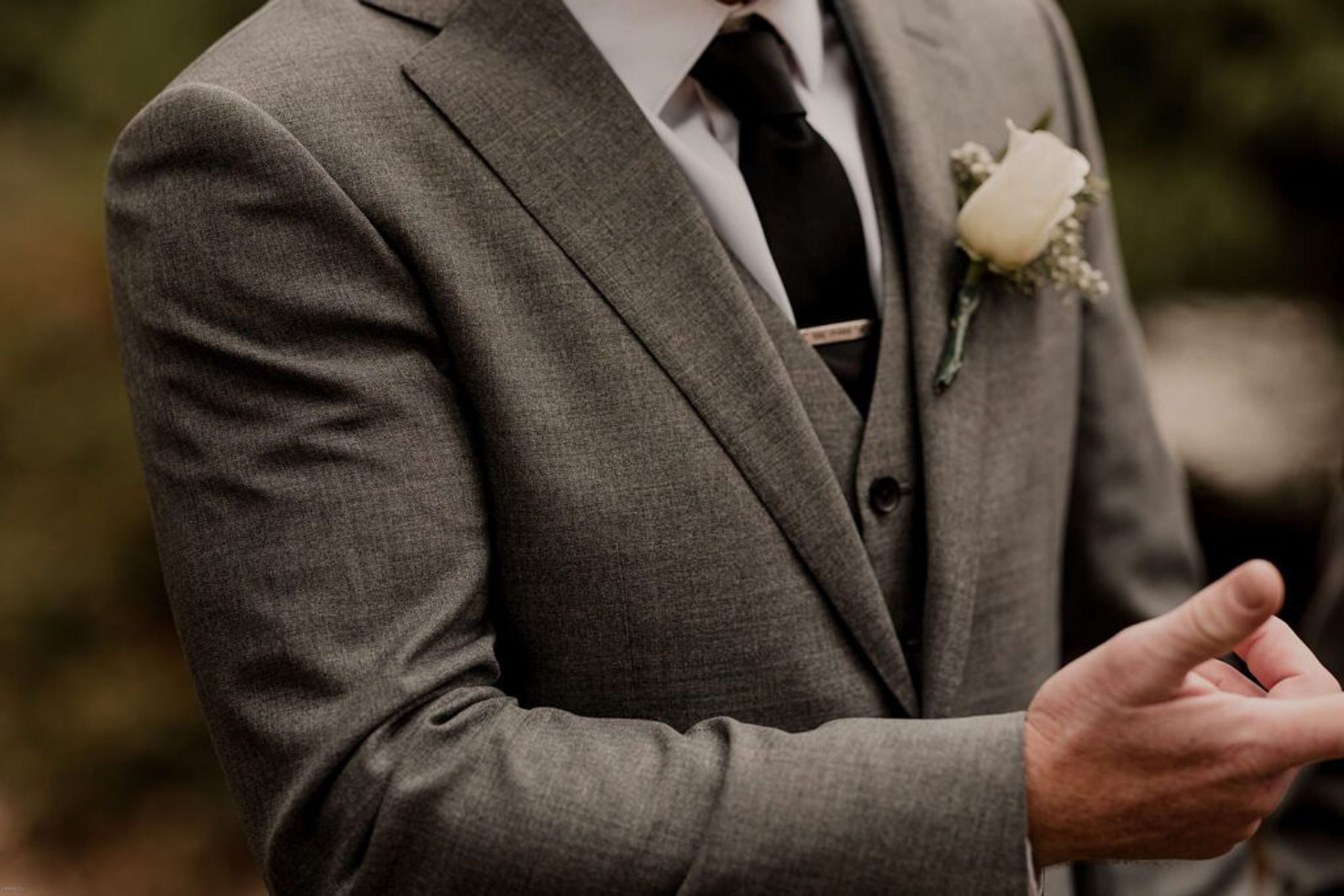 A close-up of Scott's suit and tie, highlighting the elegant details of his wedding attire.