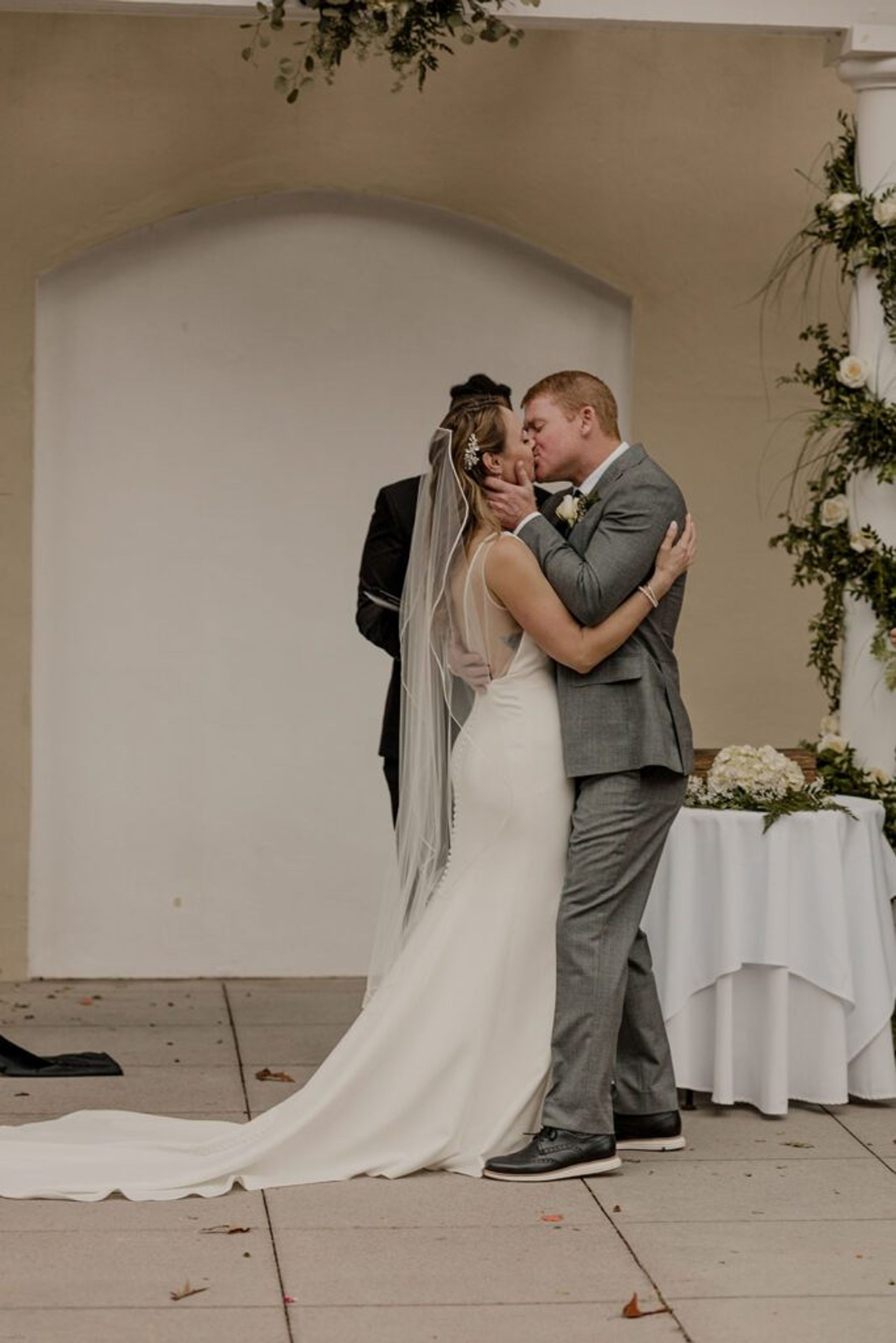 Scott and Deb share a romantic kiss at the altar at 173 Carlyle House, with Deb’s dress elegantly trailing behind.
