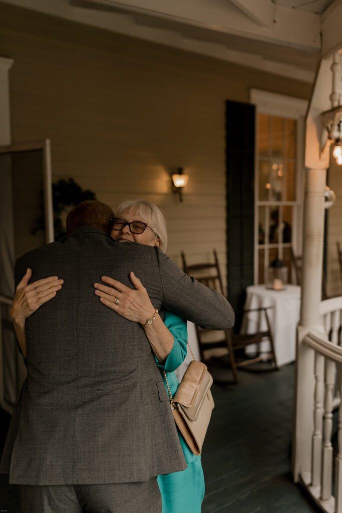 Scott warmly embraces a guest under the porch at 173 Carlyle House.