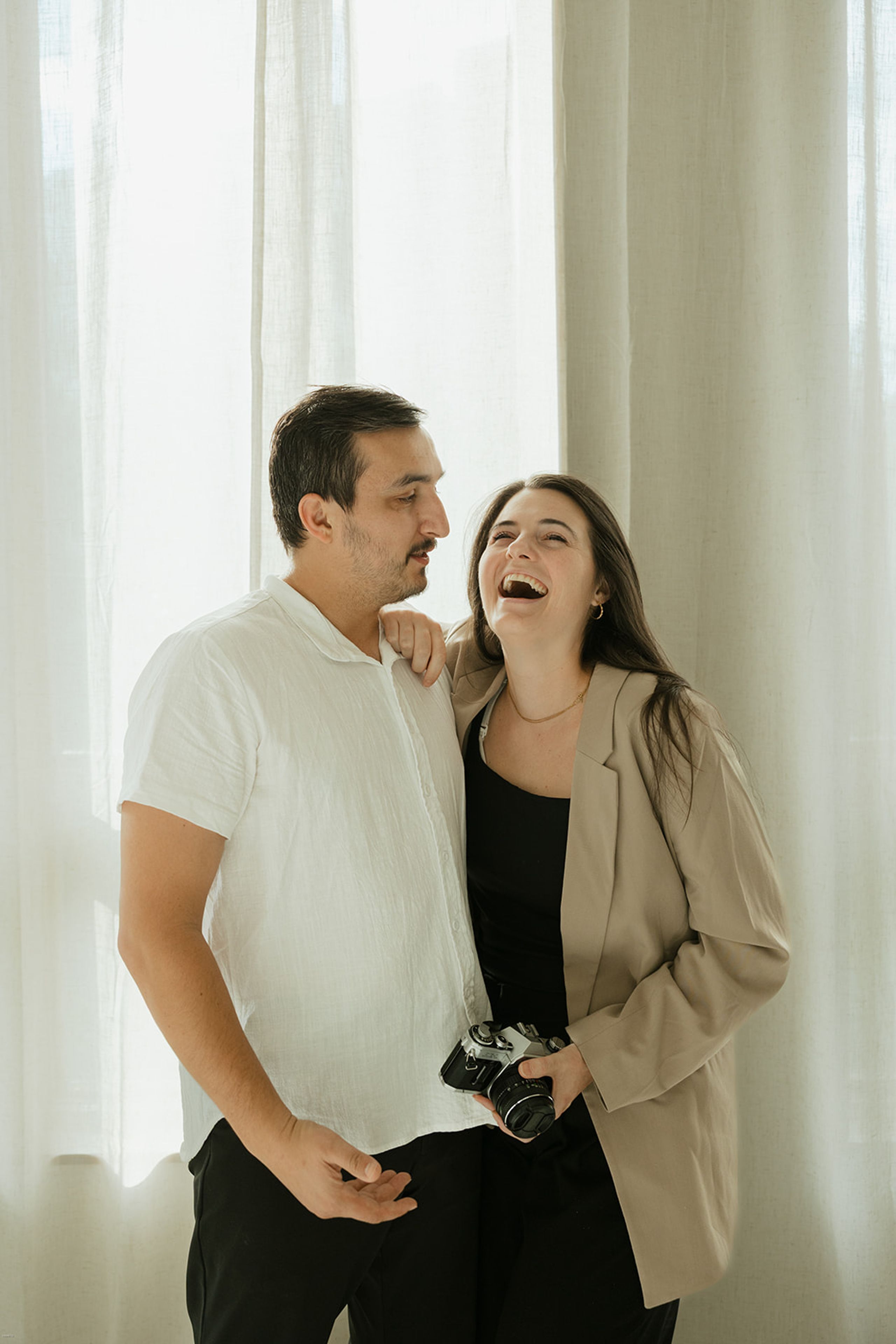 Katie and David Hevesi, Atlanta wedding photographers, smiling together indoors